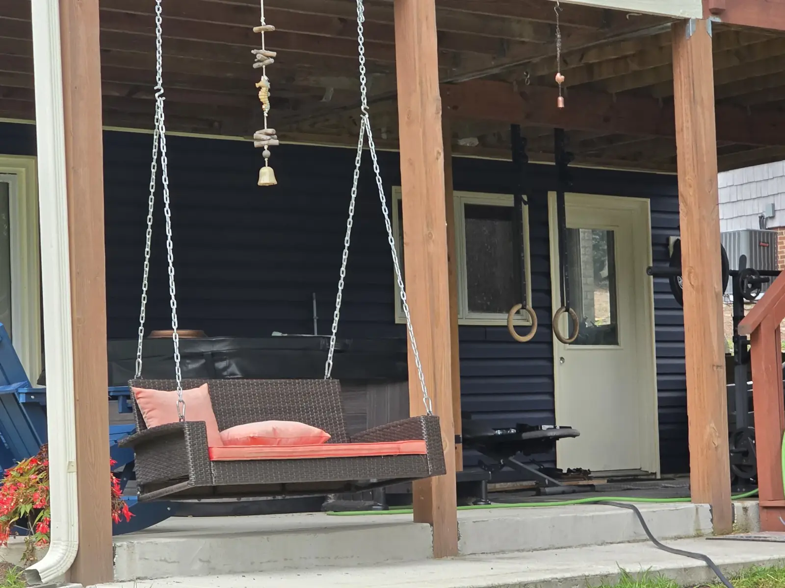 Covered patio with timber posts and navy exterior siding from VTG’s website